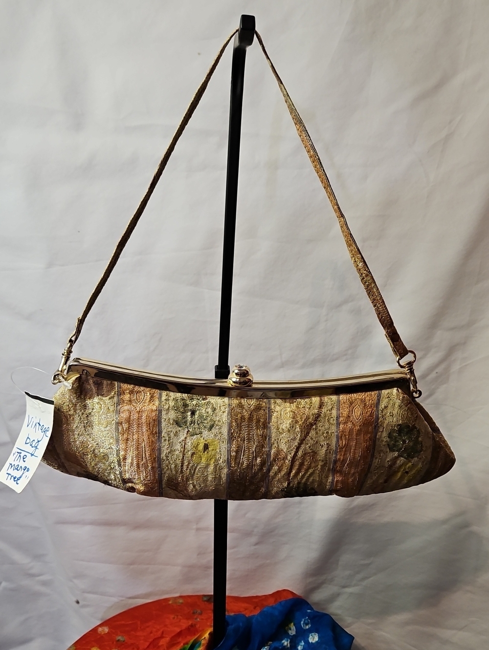 Vintage-style 1950s floral brocade handbag features a metallic clasp.
